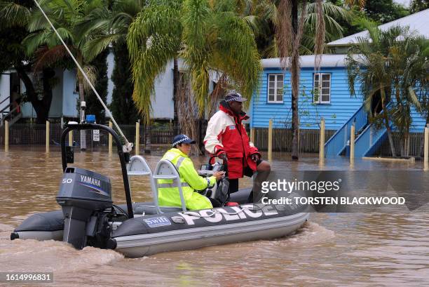 Police constable Francis Bowie patrols the flooded streets of Rockhampton for looters on January 6, 2011. Tens of thousands of people in Rockhampton...