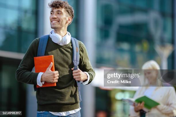porträt eines männlichen studenten, der buch hält - hochschulstudium stock-fotos und bilder