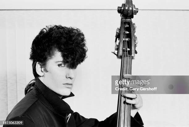 Portrait of American Rockabilly musician Lee Rocker , of the group Stray Cats, as he poses with an upright bass, Long Island, New York, June 15, 1984.