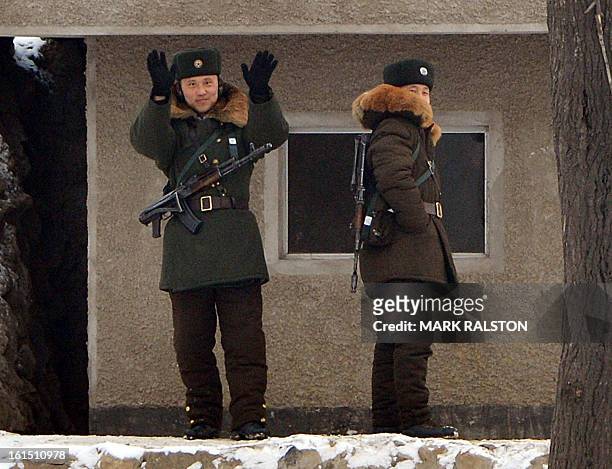 North Korean soldier gesture to a Chinese tourist boat as they stand guard beside the Yalu River near the North Korean town of Sinuiju after the...