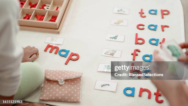 elementary girl learning words using moveable alphabet - jogo de palavras imagens e fotografias de stock
