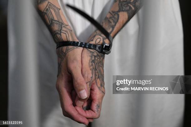 An inmate handcuffed with a plastic cable tie remains in a cell at the Counter-Terrorism Confinement Centre mega-prison, where hundreds of members of...