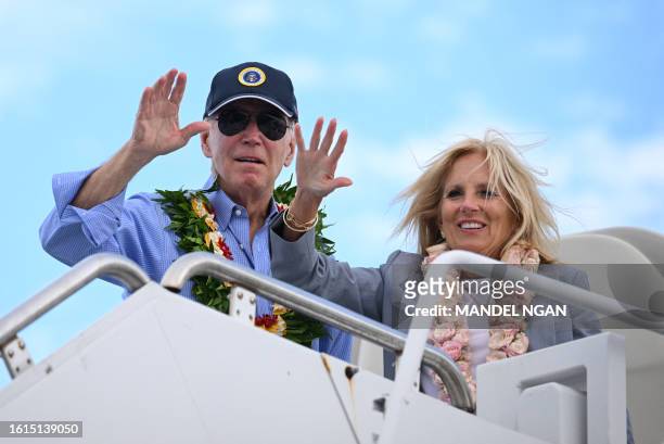 President Joe Biden and US First Lady Jill Biden wear Hawaiian leis as they wave from Air Force One before departing Kahului Airport in Kahului,...