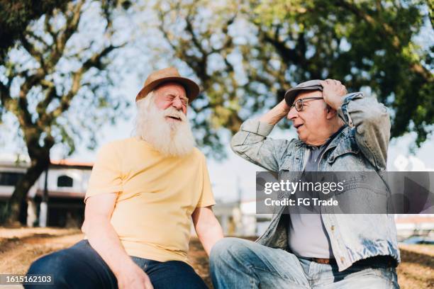 senior men talking in the park - two old men talking stock pictures, royalty-free photos & images