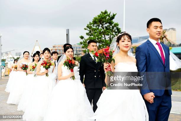Couples attend a collective wedding at Love Bay, Golden Beach Beer City in Qingdao, Shandong province, China, August 22, 2023.