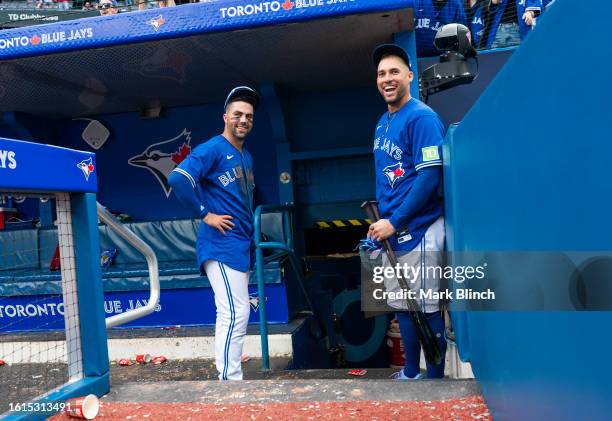 Whit Merrifield and George Springer of Toronto Blue Jays smile in the dugout before going to the locker room after their team defeated the Chicago...