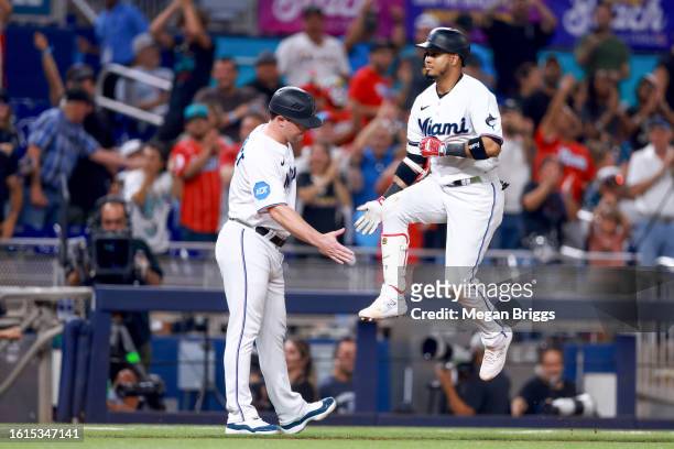 Jorge Soler of the Miami Marlins rounds the bases and shakes hands with Miami Marlins Quality Assurance Coach Griffin Benedict after hitting a home...