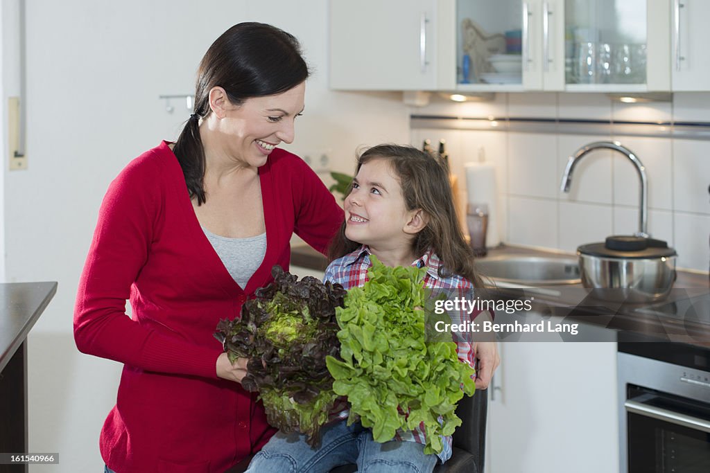 Mother and daughter with salads in a kitchen