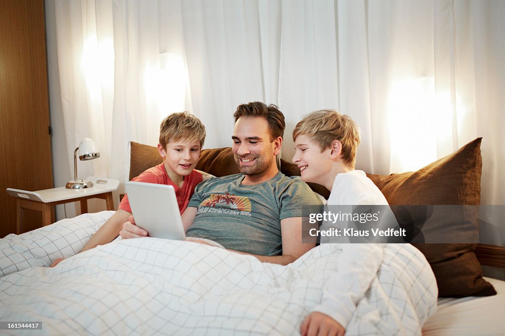 Father & sons watching youtube clip on tablet