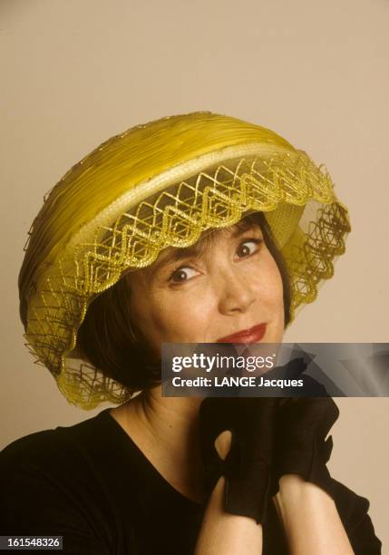 Rendezvous With Sabine Azema. Sabine AZEMA posant avec un chapeau jaune de Marie MERCIE, souriant, tête penchée.