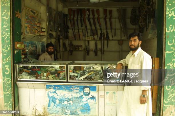 Tribal Area In Pakistan. Les marchands d'armes de la zone tribale du Pakistan : vendeur posant devant son échoppe proposant des armes en tous genres.