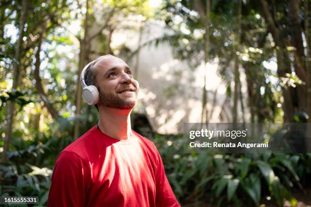 non binary person with autism listening to music with headphone - autism stock pictures, royalty-free photos & images