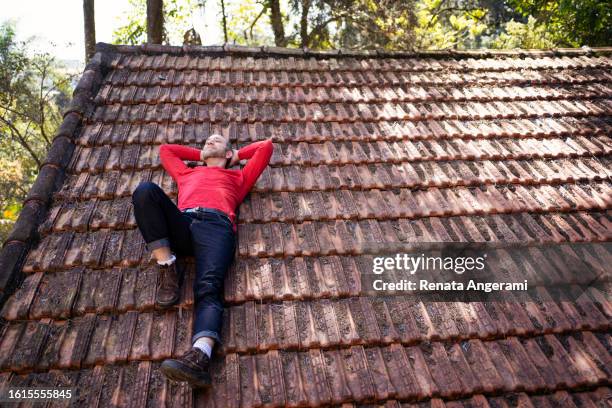 non binary person with autism lying on tiled roof - binary tree stock pictures, royalty-free photos & images