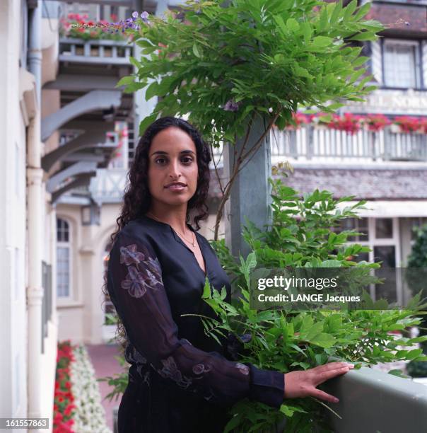 Noa Israeli Singer. NOA, chanteuse israélienne, posant sur un balcon à côté d'un bouquet de feuilles vertes.