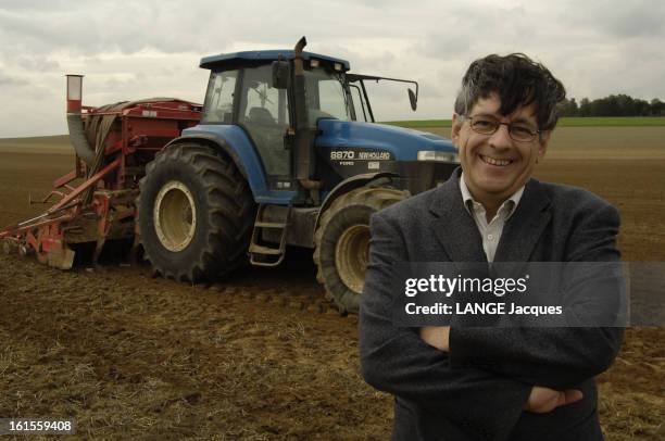 Rendezvous With Pierre Klein. Plan de face souriant de Pierre KLEIN, agriculteur moderne du IIIème millénaire, posant bras croisés devant un tracteur...