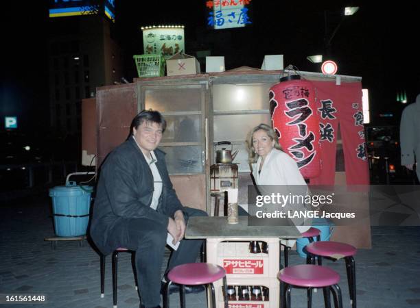 David Cozy With His Companion Valerie In Japan. Le judoka David DOUILLET et sa compagne Valérie attablés devant une échoppe, lors de leur séjour au...