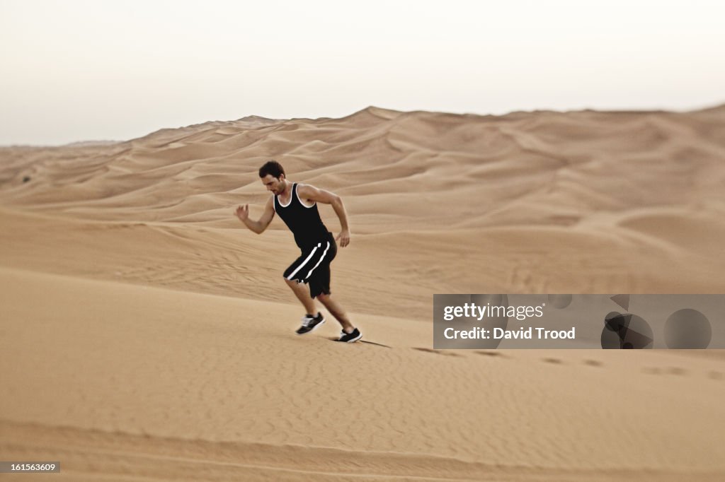 Man running in sand dunes