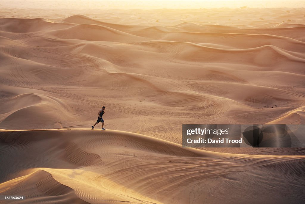 Man running in sand dunes