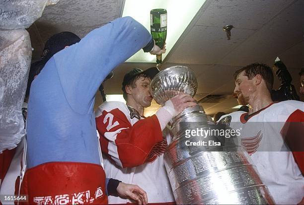 Detroit Red Wings defenseman Viachlesav Fetisov drinks champagne from the Stanley Cup in the locker room at the Joe Louis Arena in Detroit, Michigan....