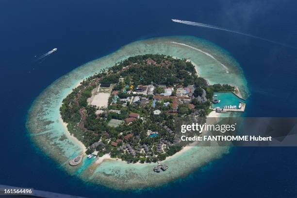 Hotel Soneva Fushi In Maldives: With The Pioneers Of Eco Luxury. Illustration of the Maldives aerial view of an island with the resort and its marina.