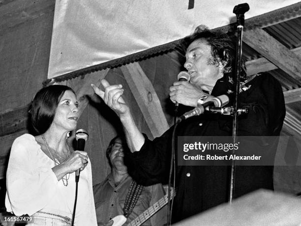 Johnny Cash and his wife June Carter Cash perform at the A.P. Carter Memorial Festival in Maces Springs, Virginia, in August 1977. A.P. Carter was...