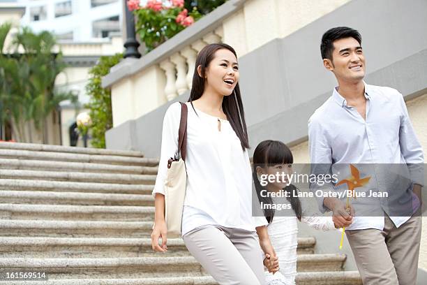 cheerful young family walking down steps in hong kong - hong kong family stockfoto's en -beelden