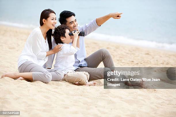 happy young family appreciating the view with binoculars on the beach of repulse bay, hong kong - asian child with binoculars stockfoto's en -beelden