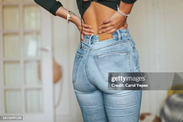 hispanic young woman having back pain - women injury stockfoto's en -beelden