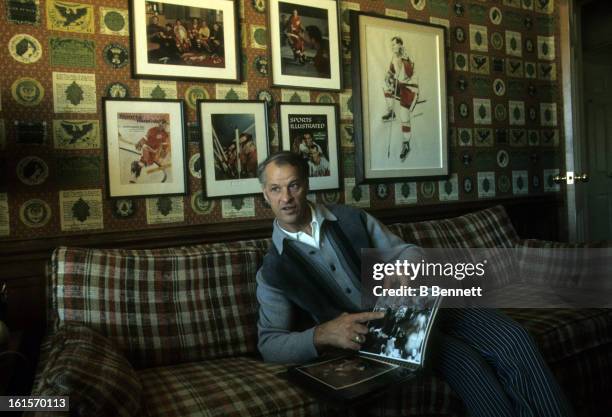 Gordie Howe of the Houston Aeros shows photographs of himself during an interview at his home circa 1975 in Houston, Texas.