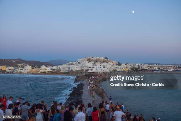 Pilgrimage of tourists at sunset to the Temple of Apollo or The Great Door is a massive marble doorway that stands proudly as the jewel of Naxos, on...