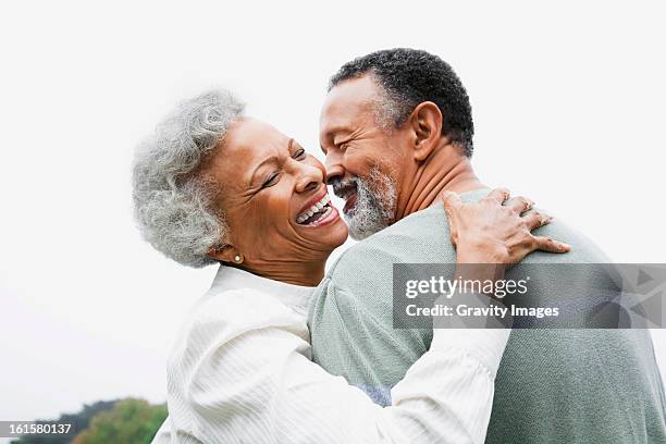 happy retired couple embracing - african american couple stockfoto's en -beelden