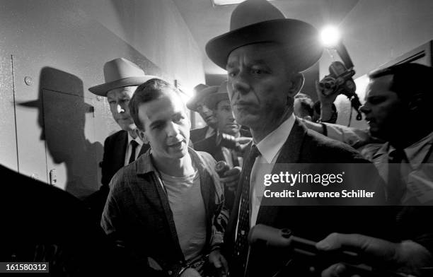 Crowded by police and members of the press, the accused assassin of President John F. Kennedy, Lee Harvey Oswald , is taken down the hall on the...