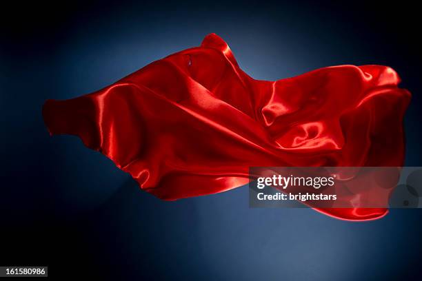 floating red silk on a dark blue background - red silk stock pictures, royalty-free photos & images