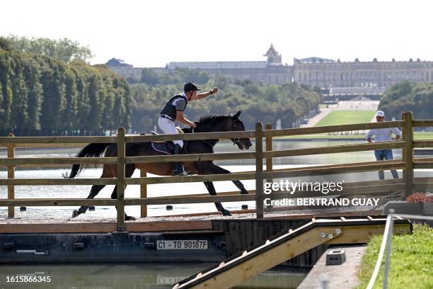 Competitor rides their horse in front of The Chateau de Versailles as he takes part in Cross Country test event ahead of the Paris 2024 Olympic...