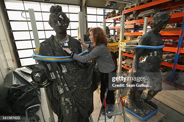 Stone restorer Frauke Herlyn attaches thin sheets of tin to an original sculpture to prepare it for the creation of a casting mould at the...