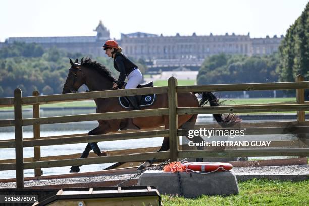 Competitor rides their horse in front of The Chateau de Versailles as she takes part in Cross Country test event ahead of the Paris 2024 Olympic...