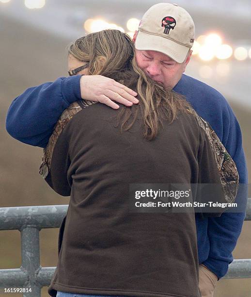 Tracy, right, and Lucinda Larimore, of Henderson, Nevada, embrace after the Chris Kyle procession passes on US 287 in Midlothian, Texas, Tuesday,...