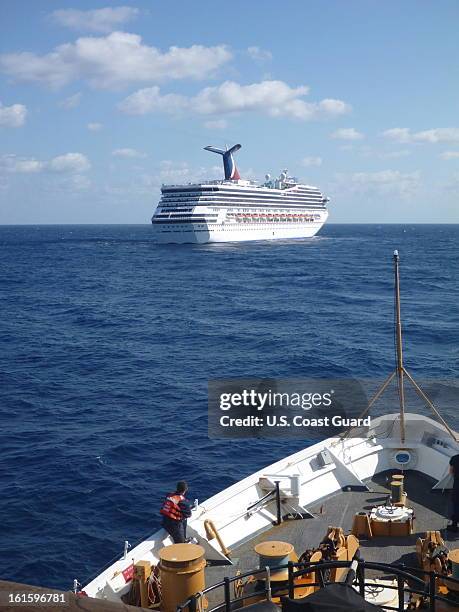 In this handout from the U.S. Coast Guard, A member of the GCG Vigorous watches as the cruise ship Carnival Triumph sits idle February 11, 2013 in...