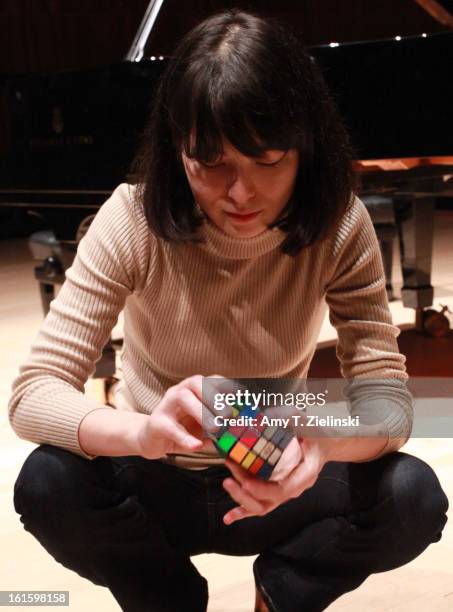 German-Japanese concert pianist Alice Sara Ott demonstrates using her Rubik's Cube to warm up her fingers after rehearsing on stage piano works by...