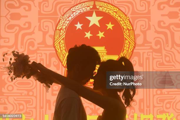 Couple poses for a photo at a marriage registration office in Hangzhou, Zhejiang province, China, Aug 22, 2023.