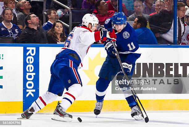 Tom Pyatt of the Tampa Bay Lightning and Josh Gorges of the Montreal Canadiens battle for control of the puck during the first period of the game at...