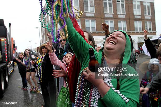 Parade goers reach for beads as the Gulf Coast Carnival Association Parade rolls down Main Street in Biloxi, Mississippi, Tuesday, February 12, 2013....