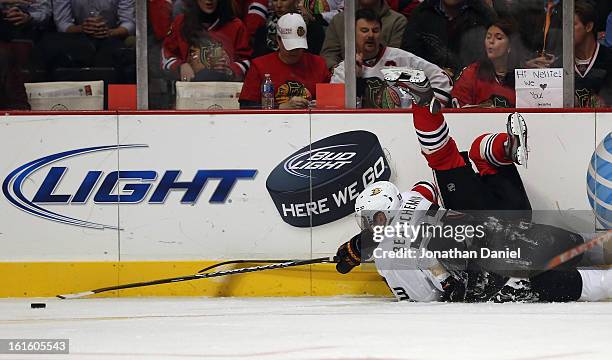 Dave Bolland of the Chicago Blackhawks gets dumped by Francois Beauchemin of the Anaheim Ducks as they battle for the puck at the United Center on...