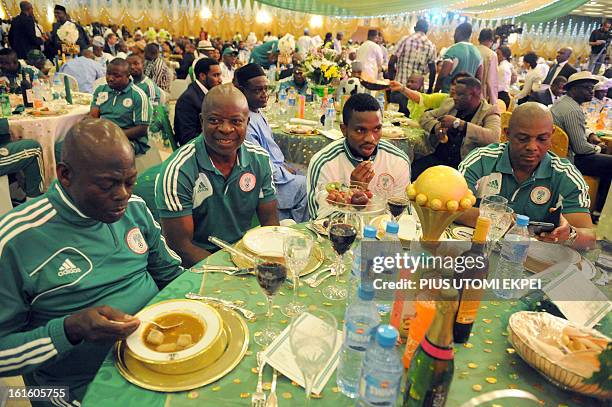 Skipper Joseph Yobo keeps trophy on the dinning table flanked by Assistant Coach Sylvanus Okpala and Coach Stephen Keshi during the presidential...