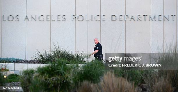 Los Angeles Police Department officer walks to police headquarters in downtown Los Angeles on February 12, 2013 in California, where media are...