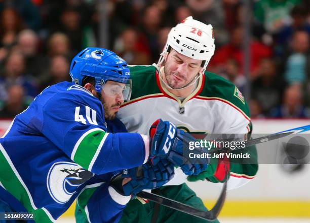 Maxim Lapierre of the Vancouver Canucks and Zenon Konopka of the Minnesota Wild collide during their NHL game at Rogers Arena February 12, 2013 in...