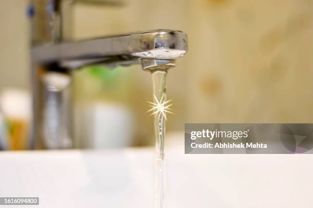 water with sparkles flowing from faucet - rainwater basin stock pictures, royalty-free photos & images