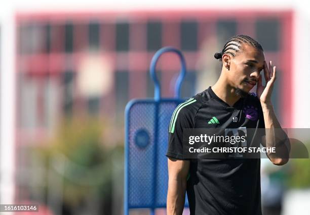 Bayern Munich's German midfielder Leroy Sane wipes his face during a public training session at the club's grounds in Munich, southern Germany, on...