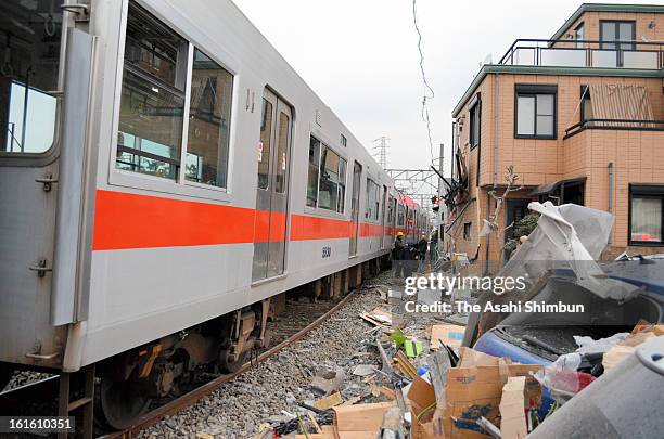 Workers investigate the derailed Sanyo Electric Railway Co. Train is seen after a collision with a truck at Arai Station on February 12, 2013 in...