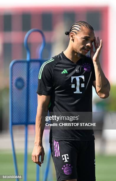 Bayern Munich's German midfielder Leroy Sane wipes his face during a public training session at the club's grounds in Munich, southern Germany, on...